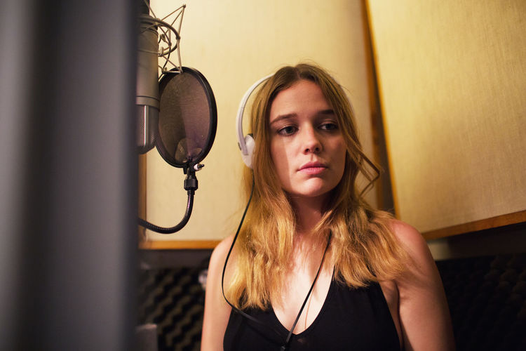 Young woman standing in recording studio