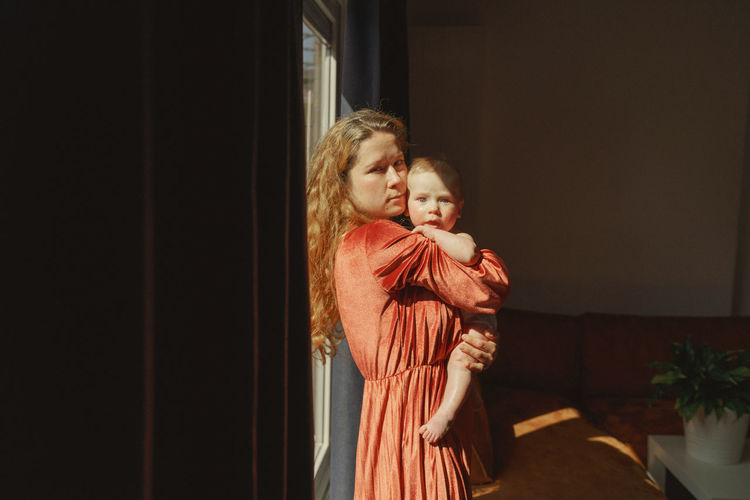 Mother and baby boy standing at home