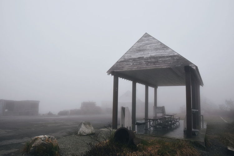 Built structure in foggy weather against sky during winter