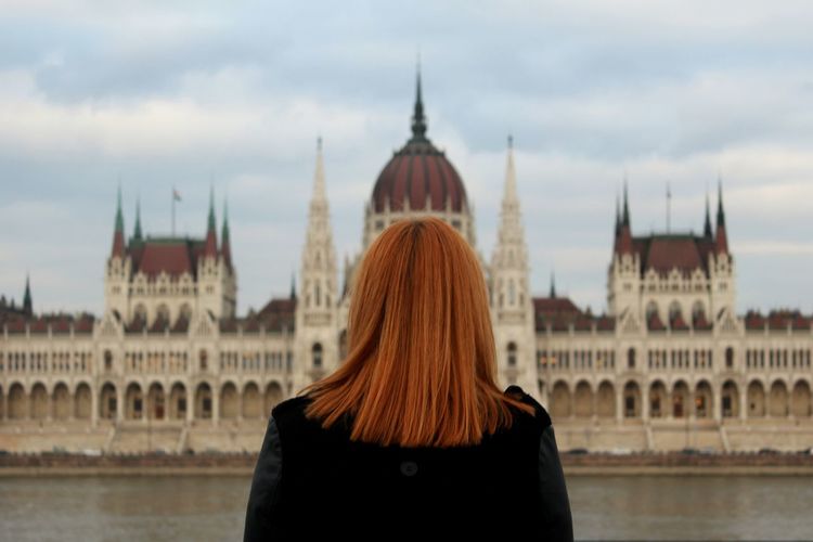 Rear view of woman against historical building