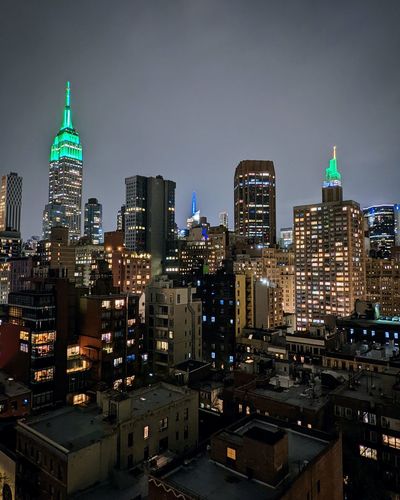Buildings in new york city illuminated in green at night for eid mubarak.