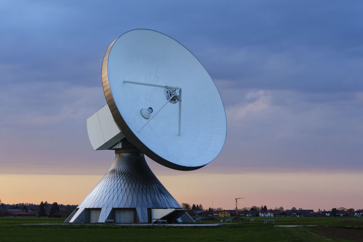 Satellite dish in city against sky