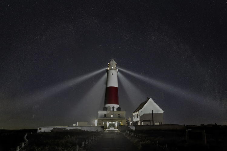 Lighthouse against sky at night
