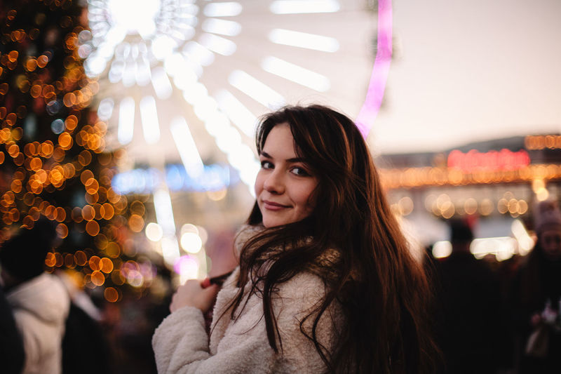 Portrait of smiling young woman at night