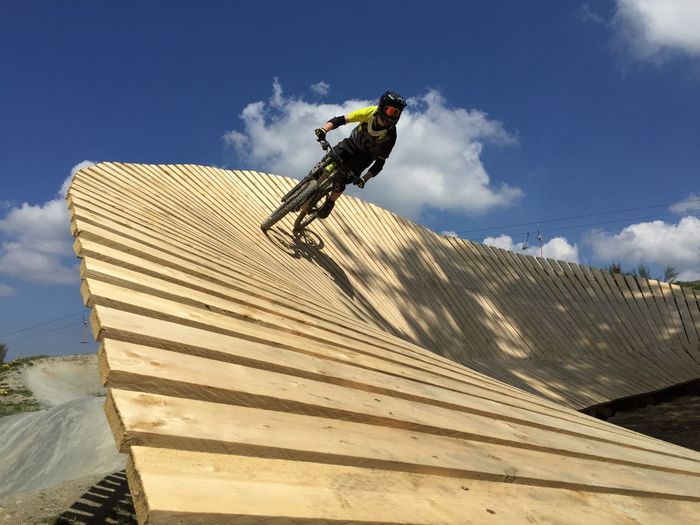 Low angle view of man riding mountainbike against sky