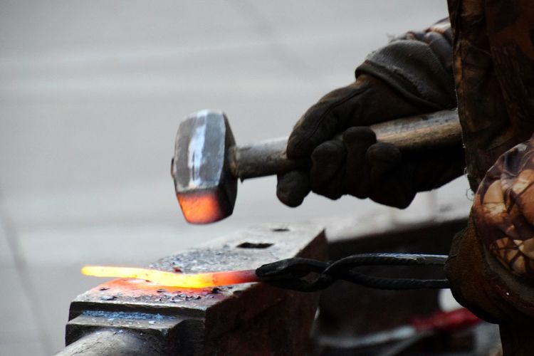 Cropped image of worker hammering metal