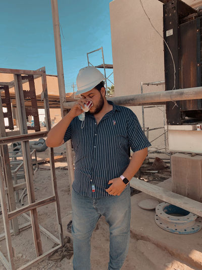 Man drinking coffee at site