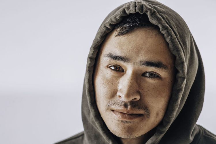 Close up horizontal portrait of asian man with hooded green sweatshirt