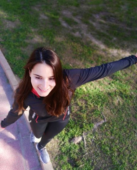 High angle view of smiling young woman walking on footpath