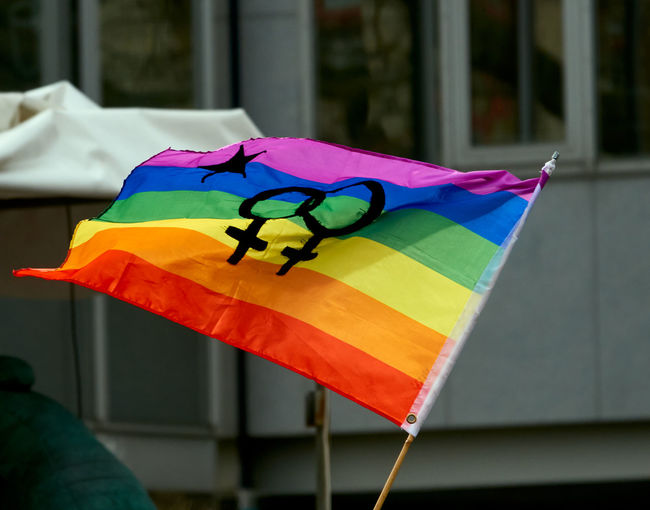Womans day 2020, rainbow flag in the wind with the double sign for femininity
