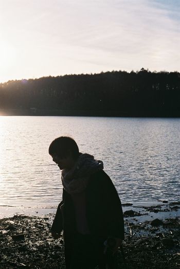 Silhouette of man in lake against sky