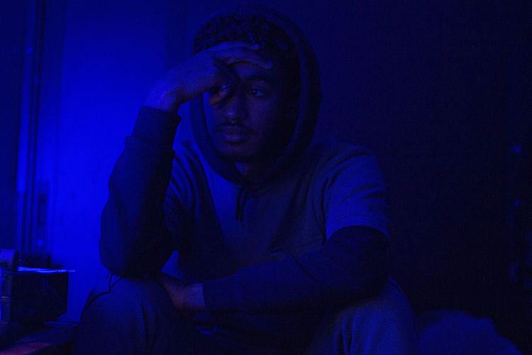 Young man standing in darkroom