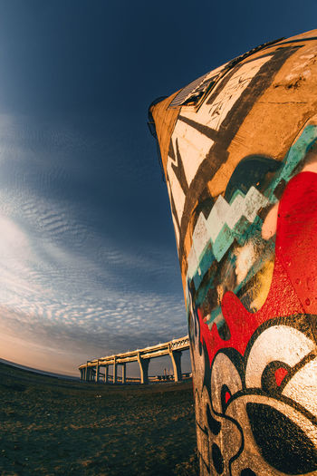 Low angle view of graffiti on built structure at sunset