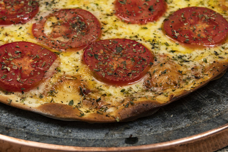 Neapolitan brazilian pizza with mozzarella cheese and tomato slices with oregano, top view