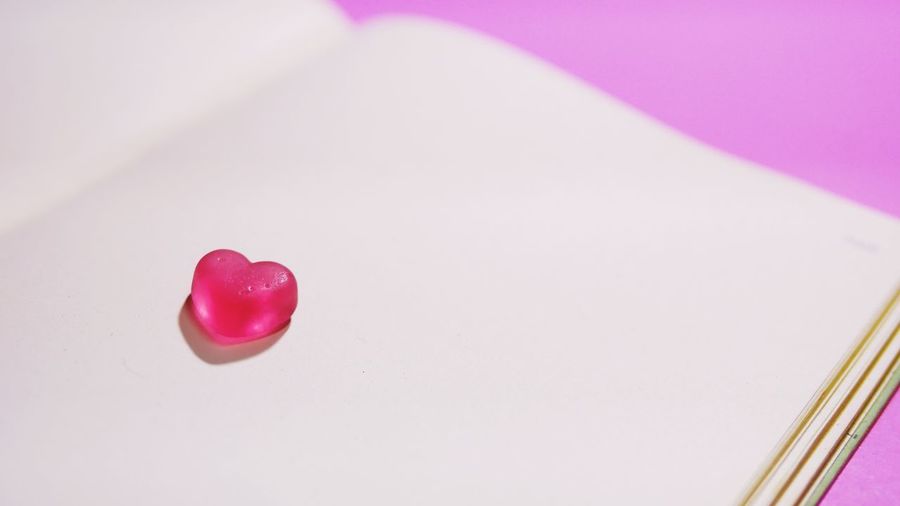 Close-up of heart shape over pink background