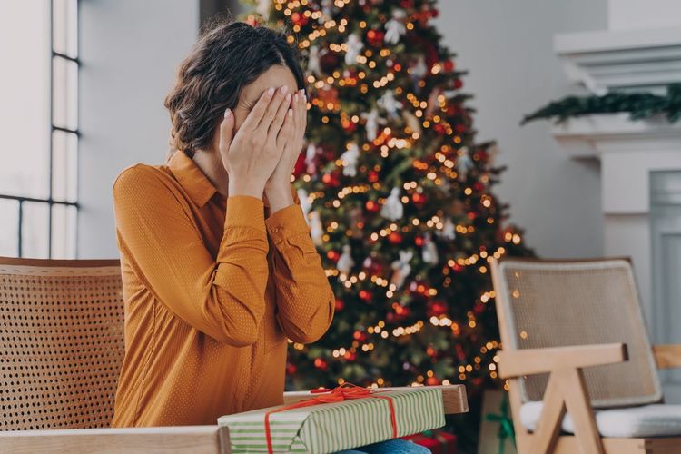 Midsection of woman with christmas tree at home