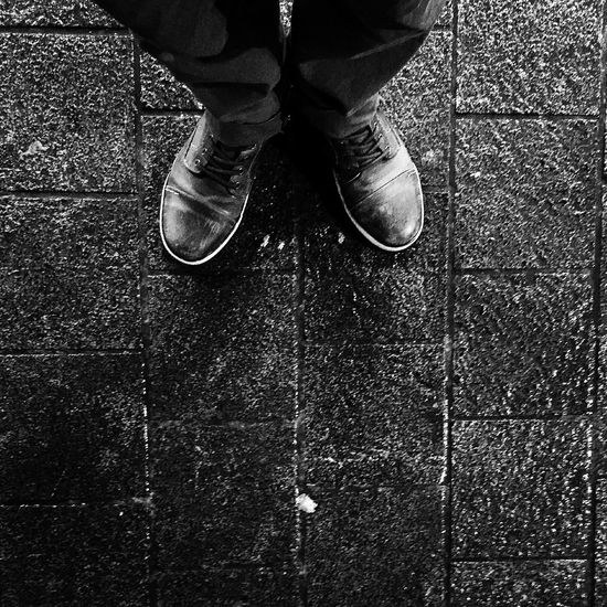 Low section of person standing on tiled floor