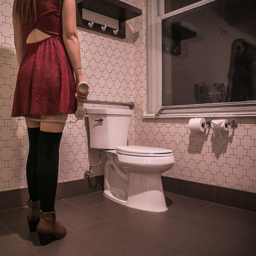 Low section of woman standing in bathroom