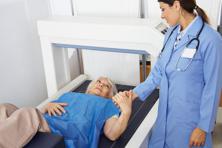 Doctor consoling patient lying at mri scanner