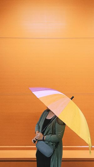 Woman holding umbrella standing in rain