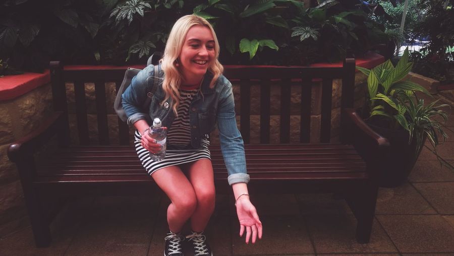 Smiling young woman sitting on bench