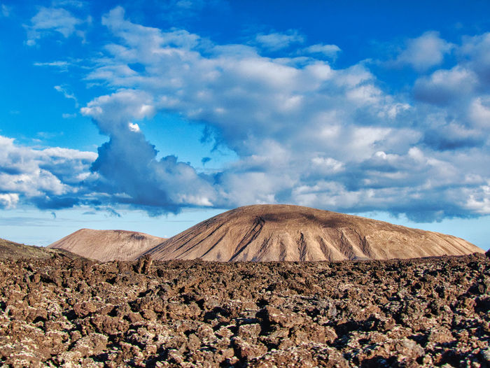 Surface level of arid land against mountain and sky