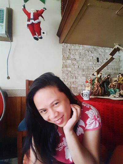 Portrait of smiling woman sitting at home
