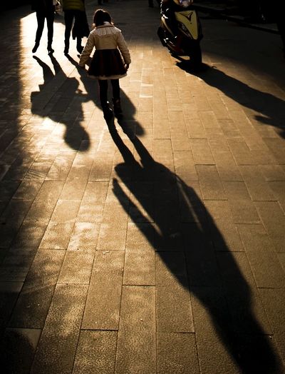 Shadow of people on sidewalk