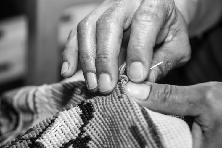 Close-up of woman sewing textile