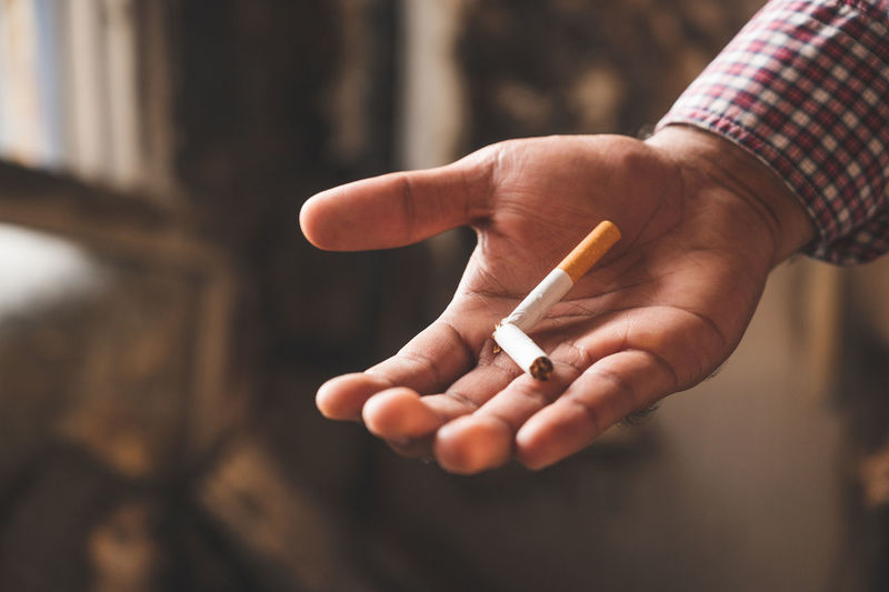 Cropped image of hand holding cigarette