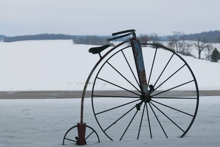 Ferris wheel in lake against sky during winter
