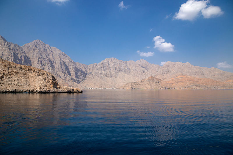 Scenic view of lake by mountains against sky