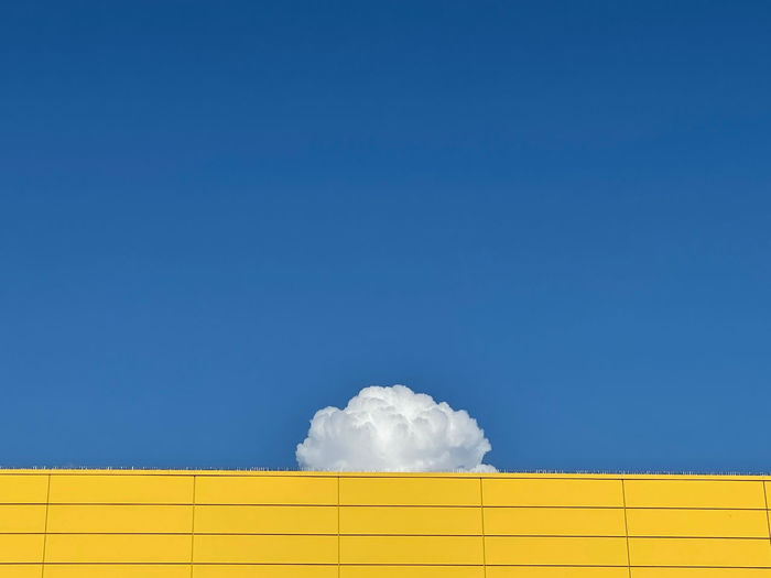 Low angle view of white wall against blue sky