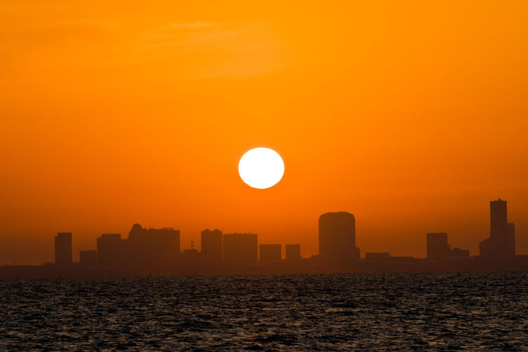 Scenic view of sea against orange sky during sunrise