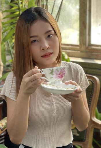 Portrait of smiling young woman having food at home