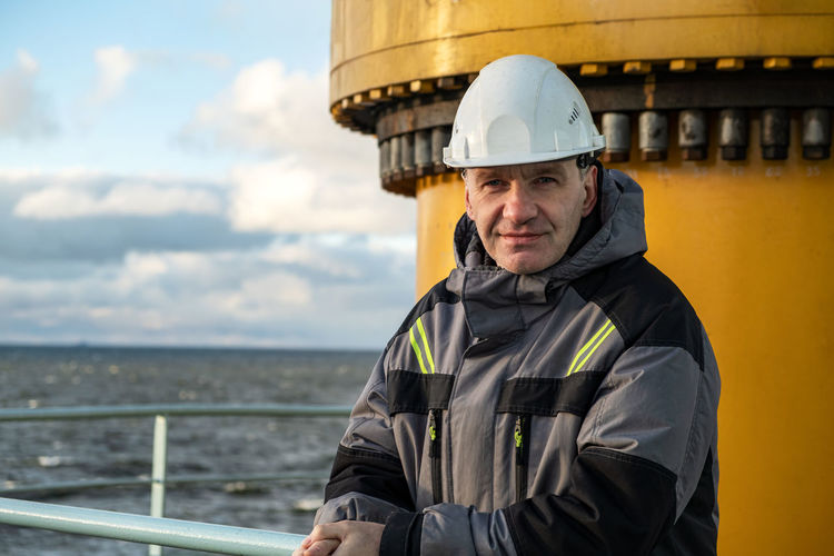 Portrait of smiling engineer standing on rig
