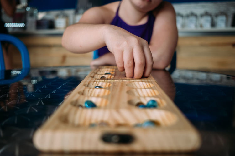 Straight on view of child playing mandala at a table