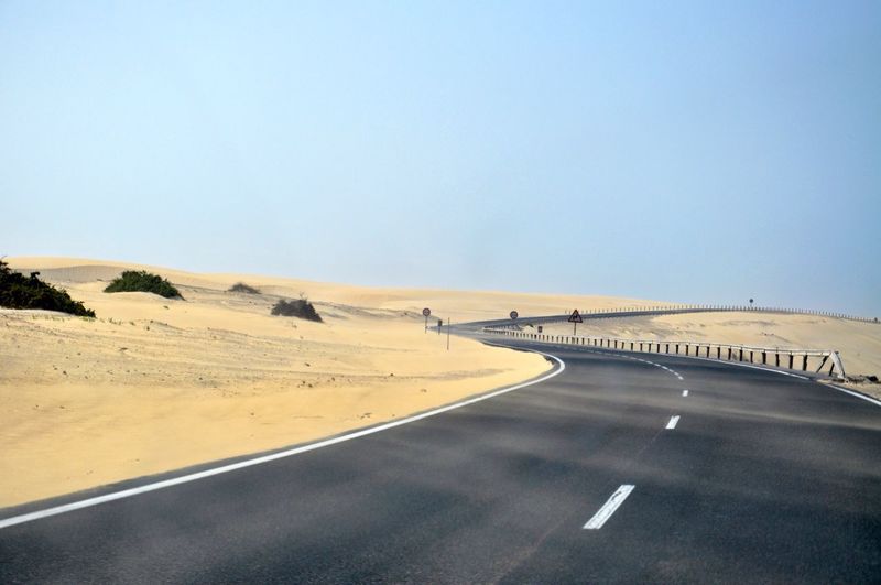 Empty road in desert against clear sky