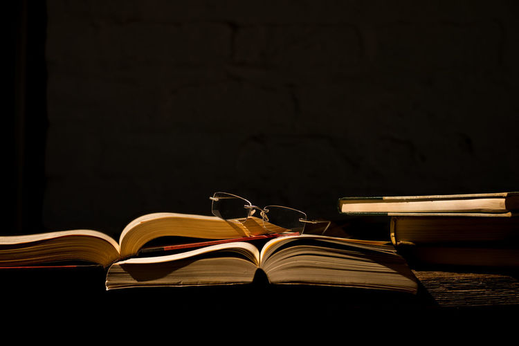 Close-up of books on table against black background