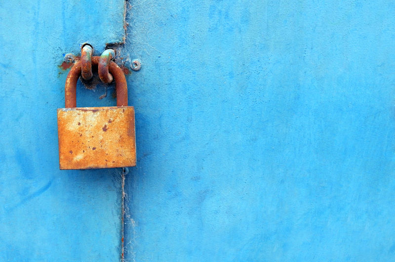 Close-up of blue doors and orange padlock