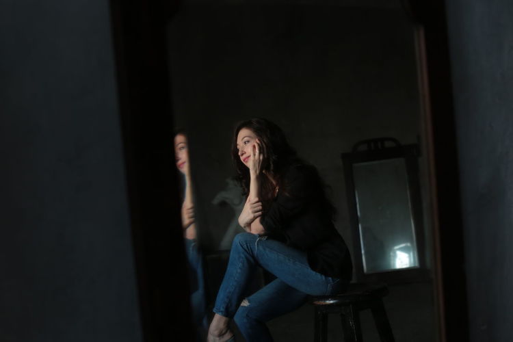 Woman sitting on stool in darkroom