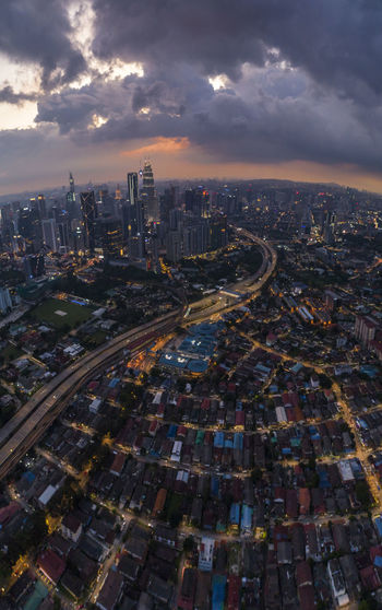 High angle view of illuminated city against sky during sunset