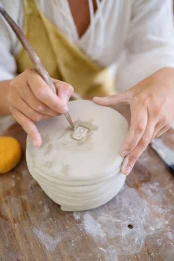 Female pottery artist making her stamp on the vase