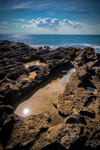 Rocks on beach against sky