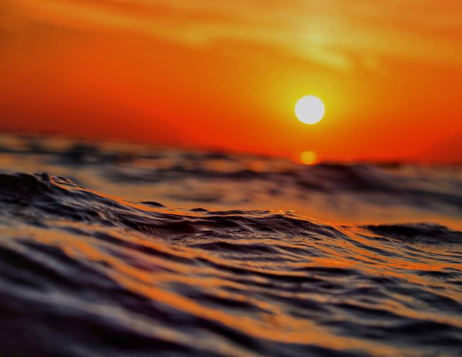Close-up of sea against orange sky