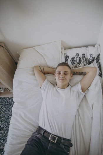 Woman lying on bed with eyes closed