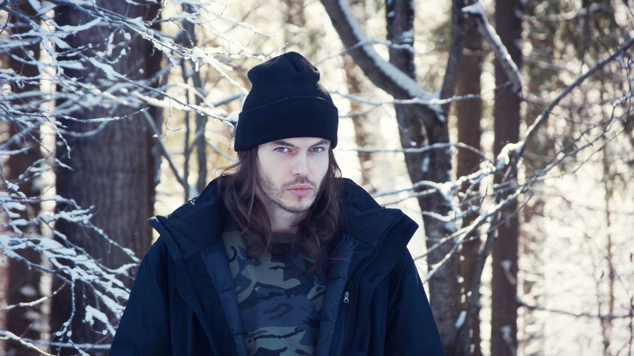 Portrait of young man in forest during winter