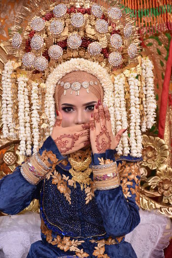 Portrait of bride showing henna tattoo on hand during wedding ceremony