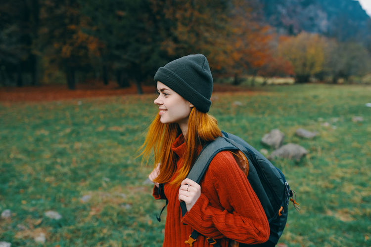 Young woman standing on field during autumn