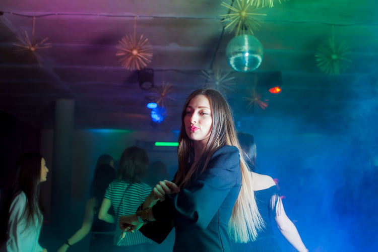 Portrait of young woman standing in nightclub